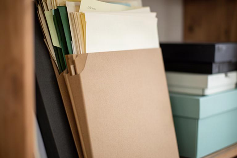 Organised paper booking records stored in a labelled folder in a small rural office